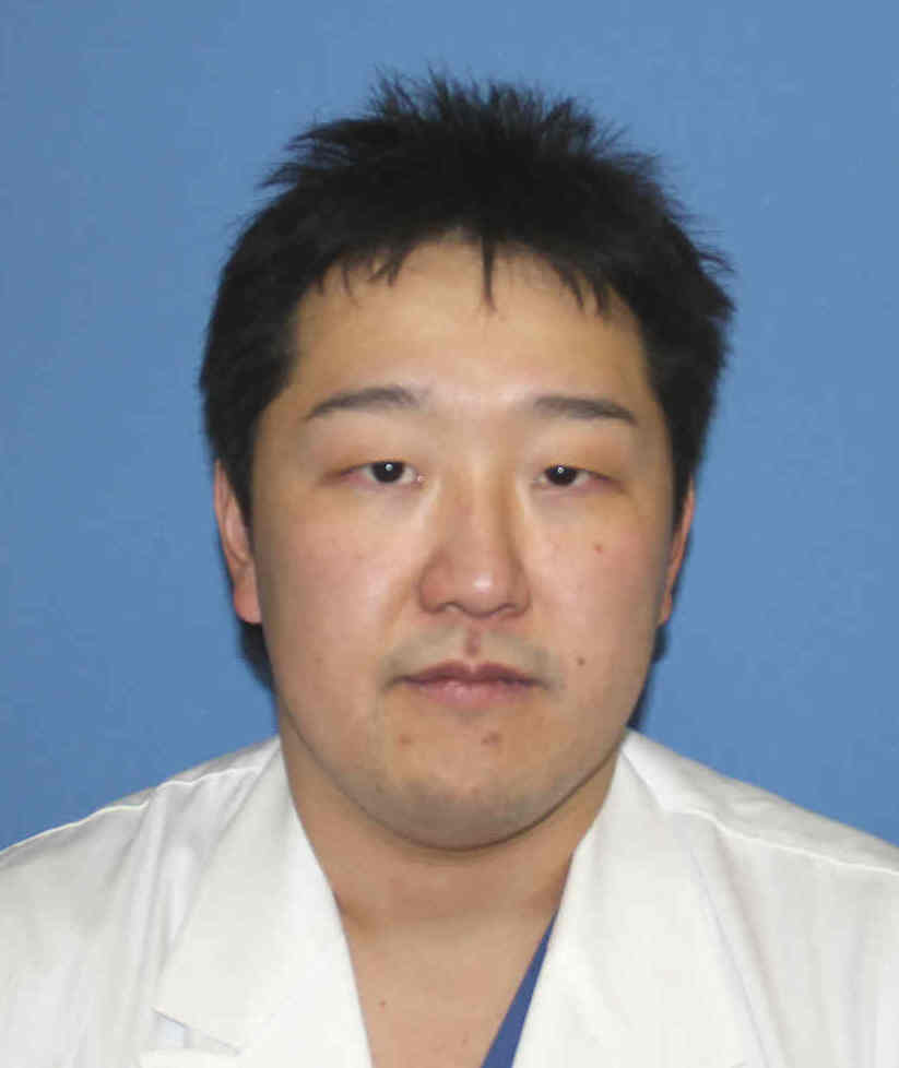 呼吸器外科の准教授、岡部直行氏のポートレート。白衣を着用し、真剣な表情でカメラを見つめている。