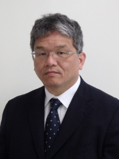 救急科部長の伊関憲氏がスーツを着て真剣な表情でカメラを見つめているポートレート。