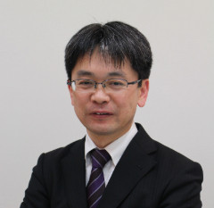 診療科部長の濱口杉大主任教授がスーツを着て微笑んでいるポートレート。