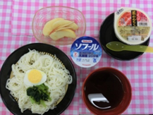 栄養管理部の食事プレート。冷やし中華、ゆで卵、ほうれん草、味噌汁、デザートのリンゴが並ぶ。