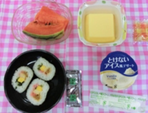 栄養管理部の食事プレートには、寿司、スイカ、プリン、アイスクリームが盛り付けられています。