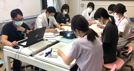 栄養管理部で個別栄養指導を行う医療スタッフが集まり、資料を確認している様子。