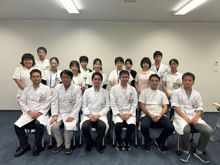 移植医療部のスタッフが集合している写真、白衣を着た医療従事者たちが笑顔でポーズをとっている。