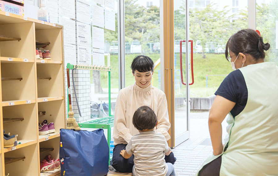 保育園で子供をあやしている写真。