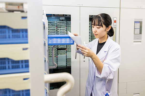 投与量・投与経路・投与速度・混合の可否の確認を行っている薬剤師の様子。