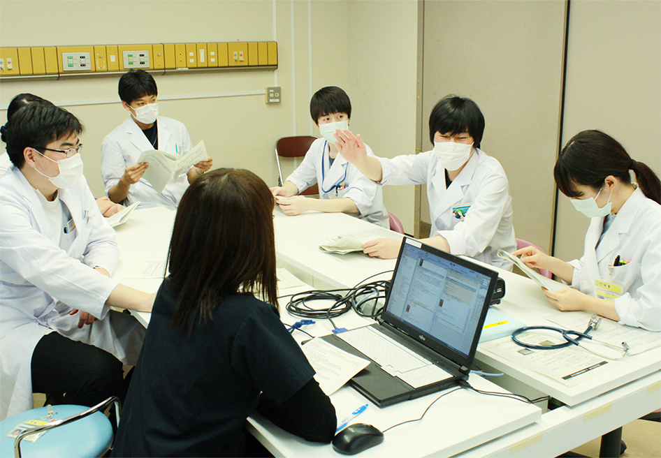 医師、看護師、栄養士、薬剤師による職種カンファレンス・院内ラウンドを行う様子。