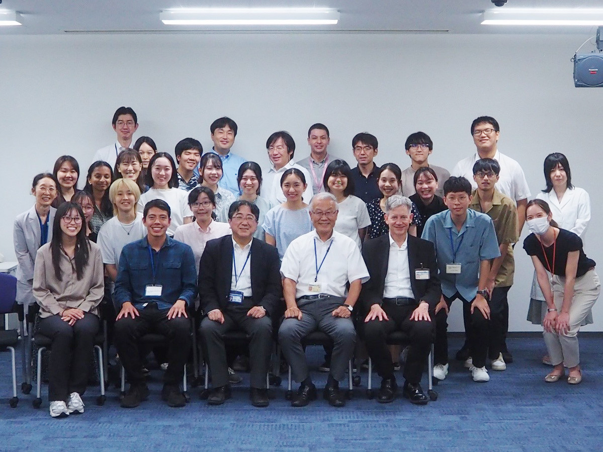 グループ写真。多くの学生と教職員が教室内で一緒に並んで笑顔でポーズを取っています。