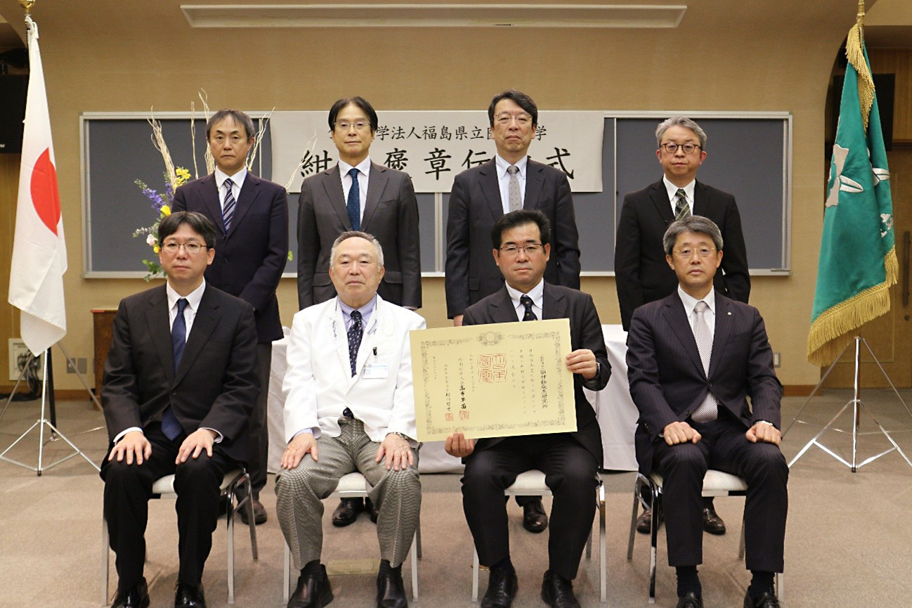 前列左より脳神経疾患研究所 常務理事 渡邉 文博様、竹之下理事長、脳神経疾患研究所 理事長 渡邉 貞義様、脳神経疾患研究所 局長 大谷 英明様　後列本学役員