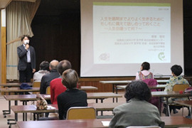 人生会議についての講演を行う講師と聴衆がいる会場の様子。