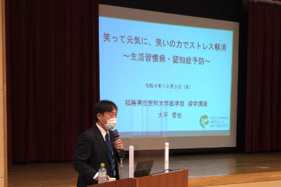 講演中の大平教授が「笑いの力でストレス解消」について説明している様子。