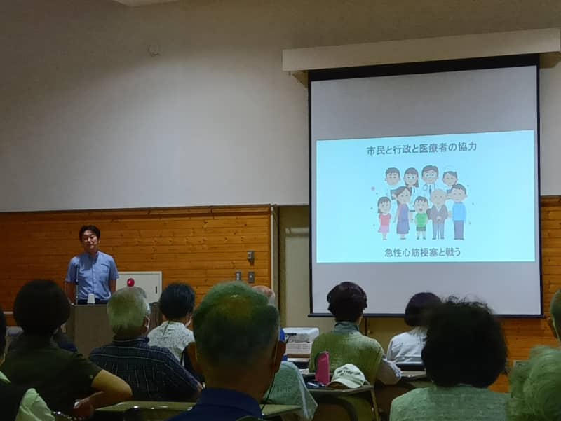 健康寿命を目指す講演会の様子。講師がスライドを使い、心筋梗塞と生活習慣について説明している。