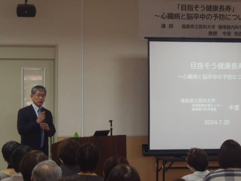 講演会で話す中里和彦教授と聴衆、テーマは心臓病と脳卒中の予防。