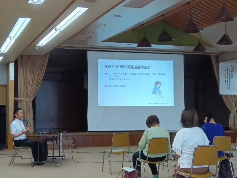 講演会で話す林博史教授と聴衆の様子、テーマは「健康と睡眠」。