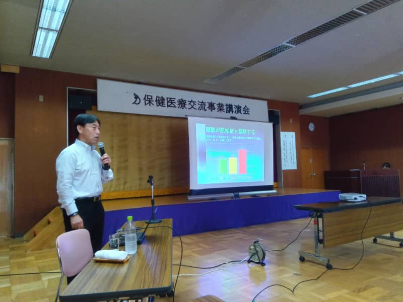 講演中の講師がスライドを使って認知症に関する説明をしている様子。