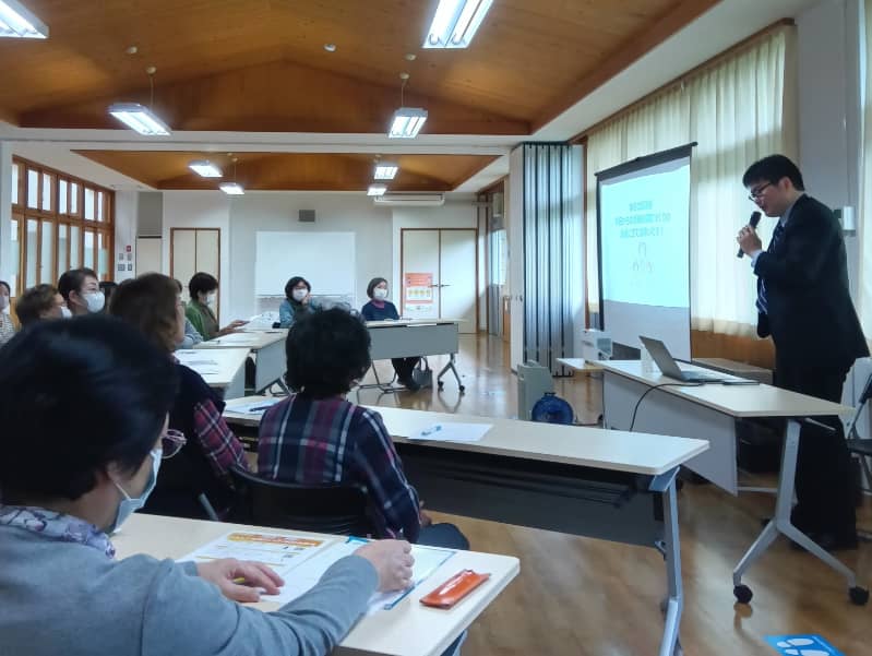健康に関する講演を受ける参加者たちが、講師の話を真剣に聞いている様子。