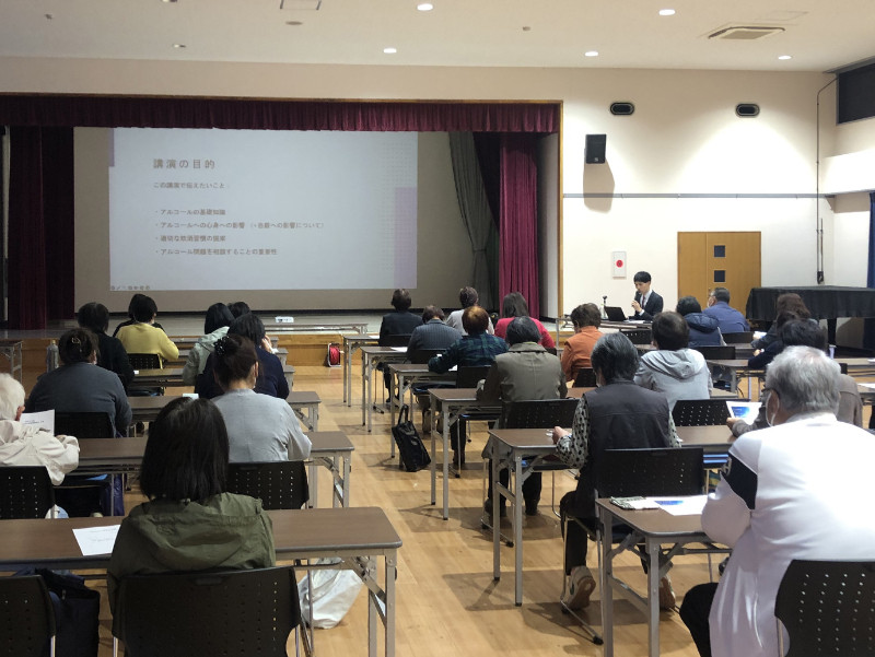 講演会で「こころの不調とアルコール」について話す森湧平先生と参加者たちの様子。