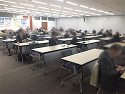 多くの人々が座っている広い会議室