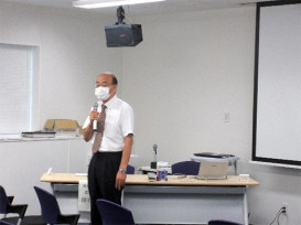 講義室で話すマスク着用の男性