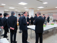 スーツ姿の男性たちが会話をしている会場内の様子