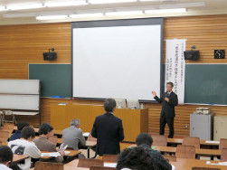 プレゼンテーションを行う講師とそれを聞く学生たちの様子