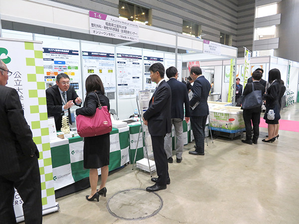 来場者が説明を聞きながら製品や資料を見学している様子