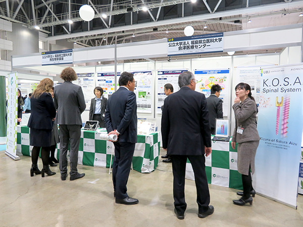 訪問者に研究結果の説明やブース内へ案内する様子