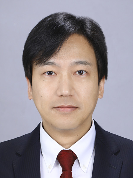生体物質研究部門の人見祐基准教授のポートレート。真面目な表情で正面を向いている。