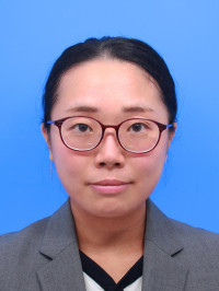 福島県立医科大学の腫瘍内科学講座主任教授、佐治重衡氏のポートレート。白衣を着用し、背景には書類や小物が並ぶ。