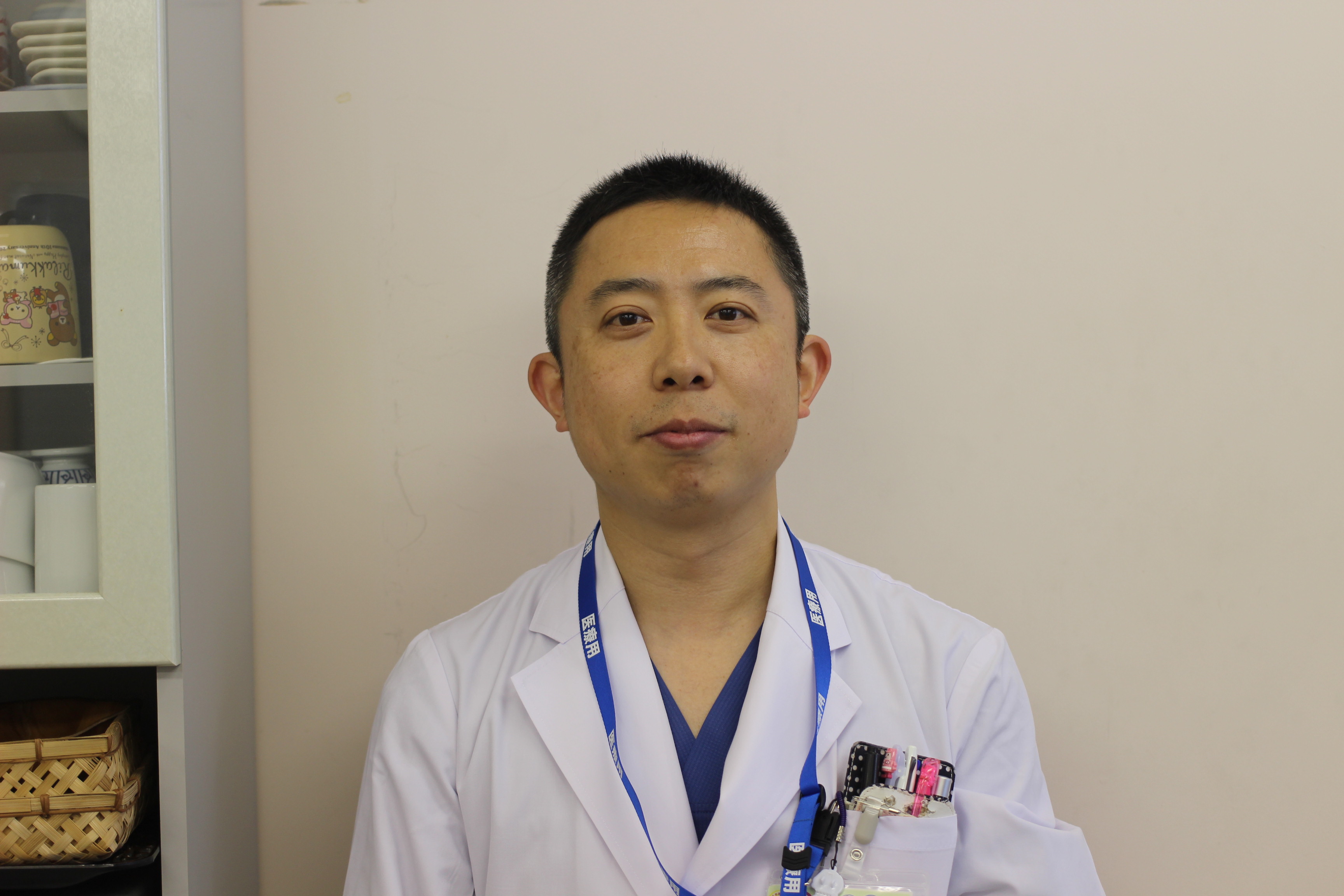 泌尿器科学講座の佐藤雄一准教授のポートレート。真面目な表情で正面を向いている。