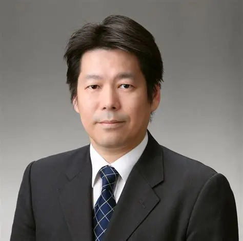 福島県立医科大学の放射線腫瘍学講座の教授がスーツを着て真剣な表情で立っている。