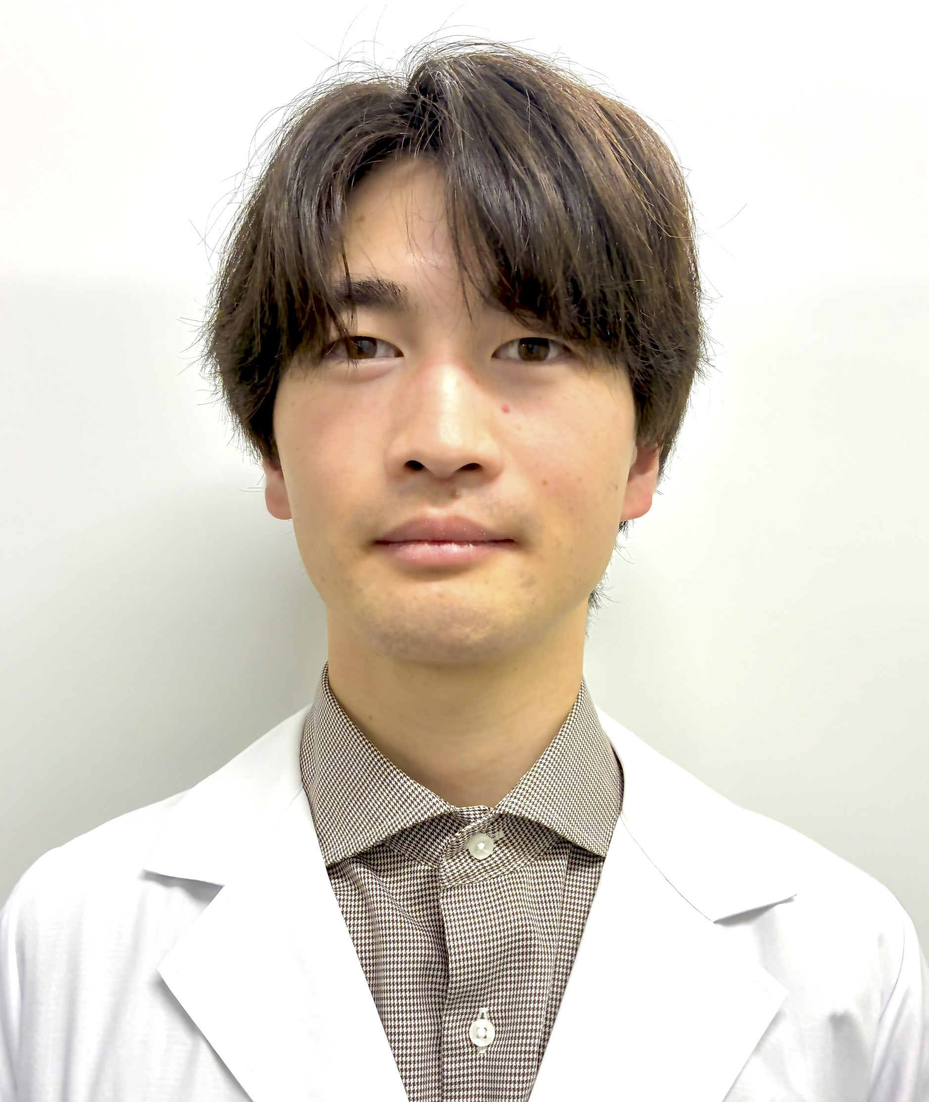 臨床検査学科の渡邊大学院生が正面を向いてまじめな表情をしているポートレート。