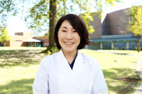 医療白衣を着た男性のポートレート、青い背景の前で真剣な表情をしている。