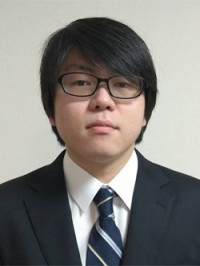 医療白衣を着た男性のポートレート、青い背景の前で真剣な表情をしている。