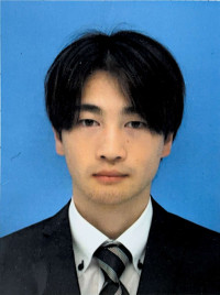 福島県立医科大学の助手、小河原崚氏のポートレート写真。白衣を着て微笑む姿。