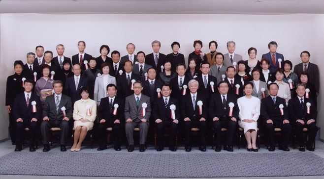 解剖実習に貢献した中村氏が塩谷文部科学大臣と共に記念写真を撮影した場面。受賞者たちが集まる式典の様子。