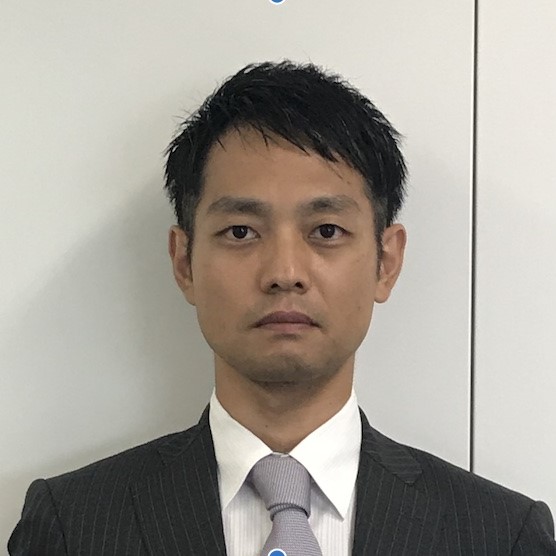 医療関係者の男性がスーツを着て真剣な表情でカメラを見つめているポートレート。