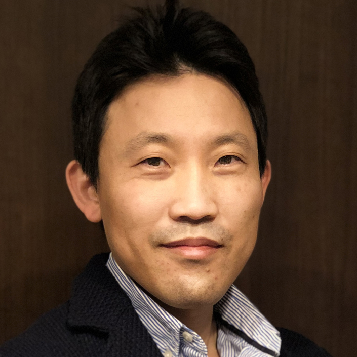 岡山洋和講師のポートレート。医療と研究に従事する姿勢を表現。