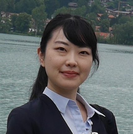 福島県立医科大学の医療人教育に従事する女性が湖の前で微笑んでいる写真。