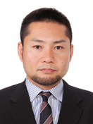 医師の井上直和准教授の公式なプロフィール写真。ビジネススーツを着用し、真剣な表情でカメラを見つめている。