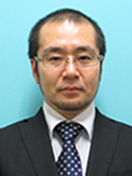山内宏之氏のポートレート。青い背景の前でスーツを着用し、真剣な表情を浮かべている。