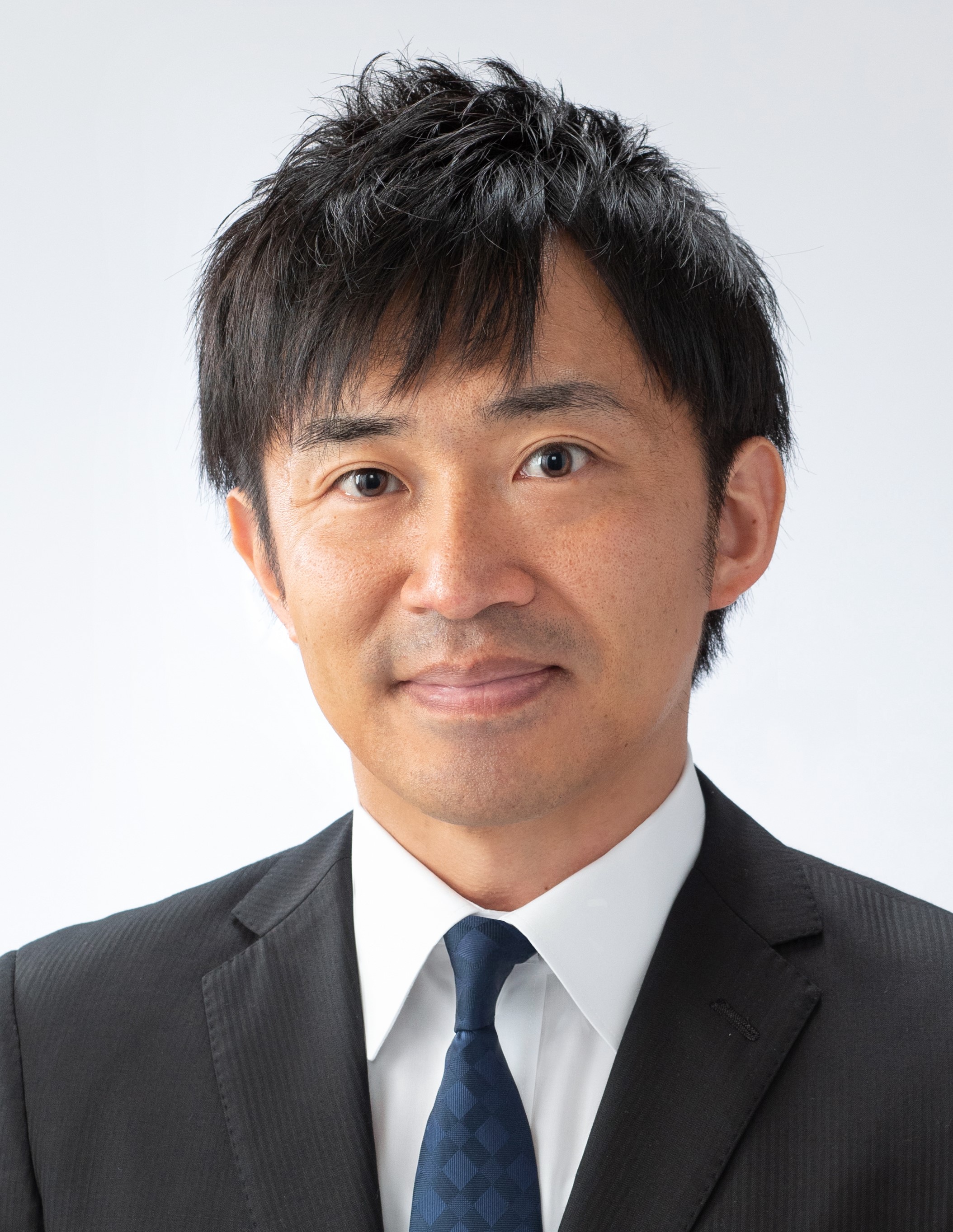 医療に従事する森山信彰氏のポートレート、スーツ姿で微笑む。