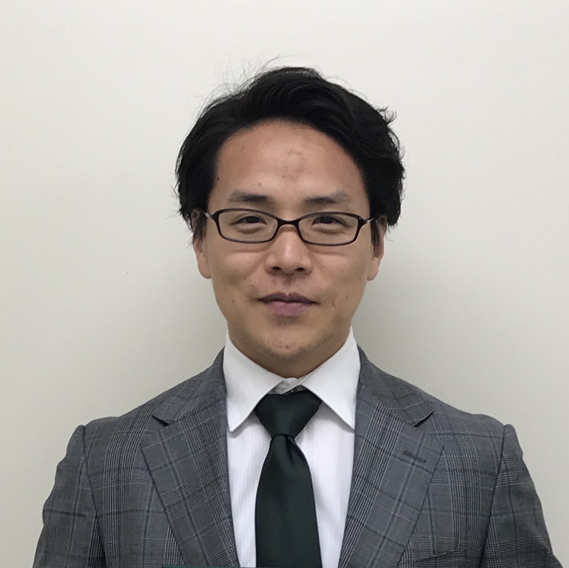 医学部の助教、藤宮剛氏がスーツ姿で微笑んでいるポートレート。背景は無地の白。
