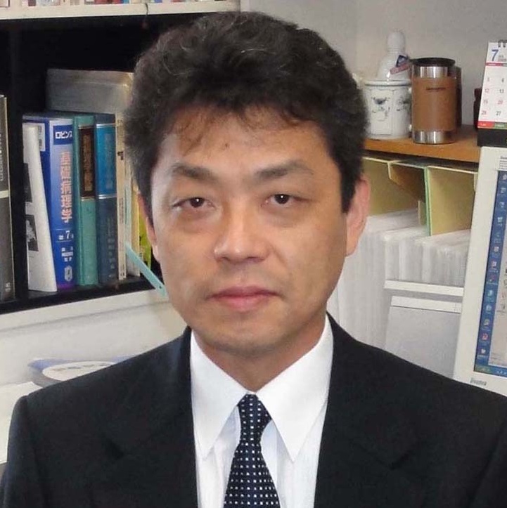 千葉英樹教授がスーツを着て微笑んでいるポートレート。背景には書籍や資料が並ぶ研究室の一部が見える。