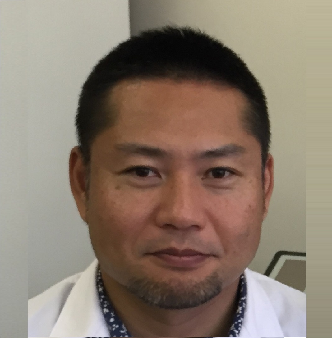 医療白衣を着た男性の顔写真。研究者としての専門性を示す表情。