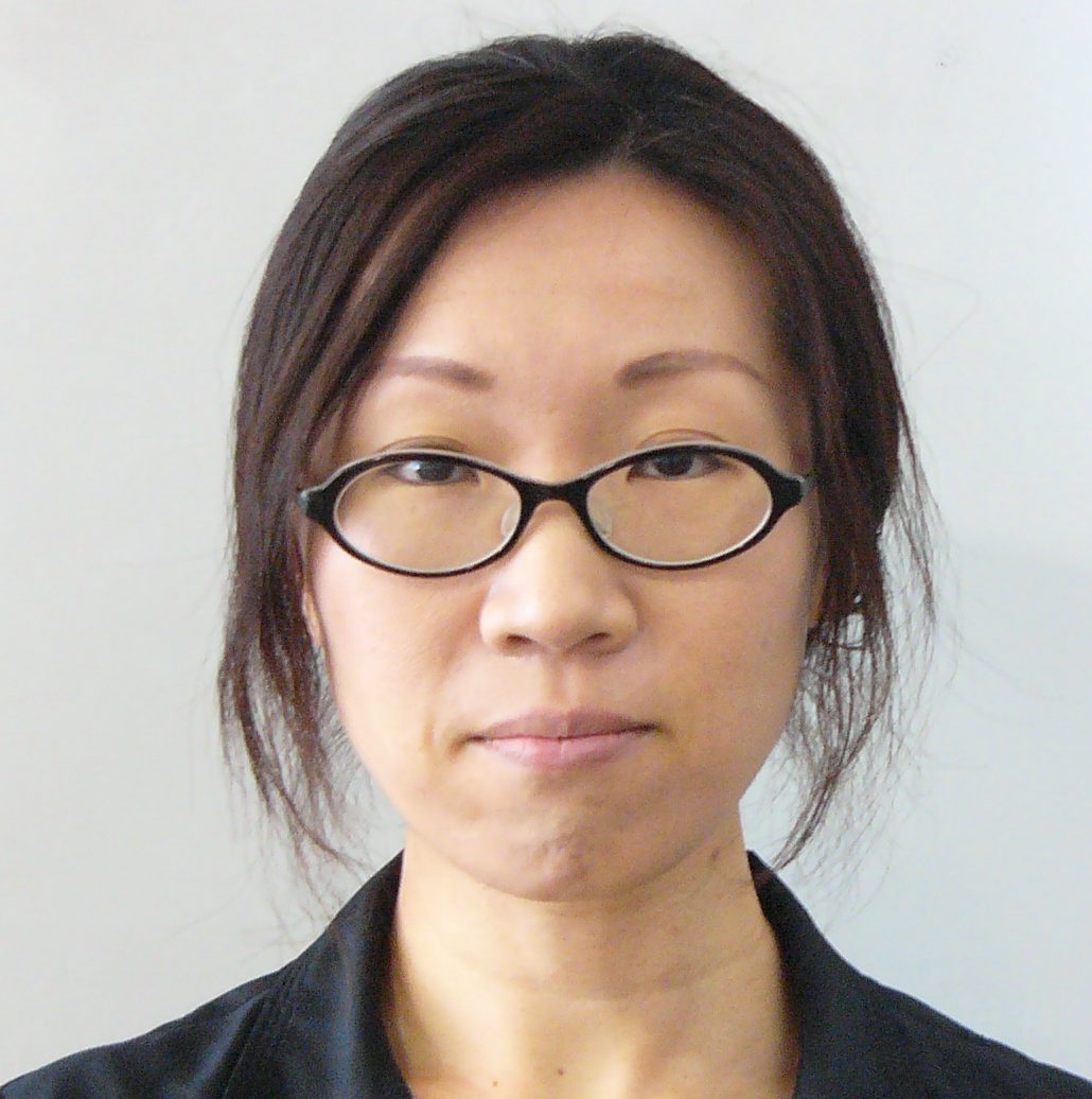 中山裕子博士のポートレート。眼鏡をかけた女性がカメラを見つめている。背景は無地の明るい色。