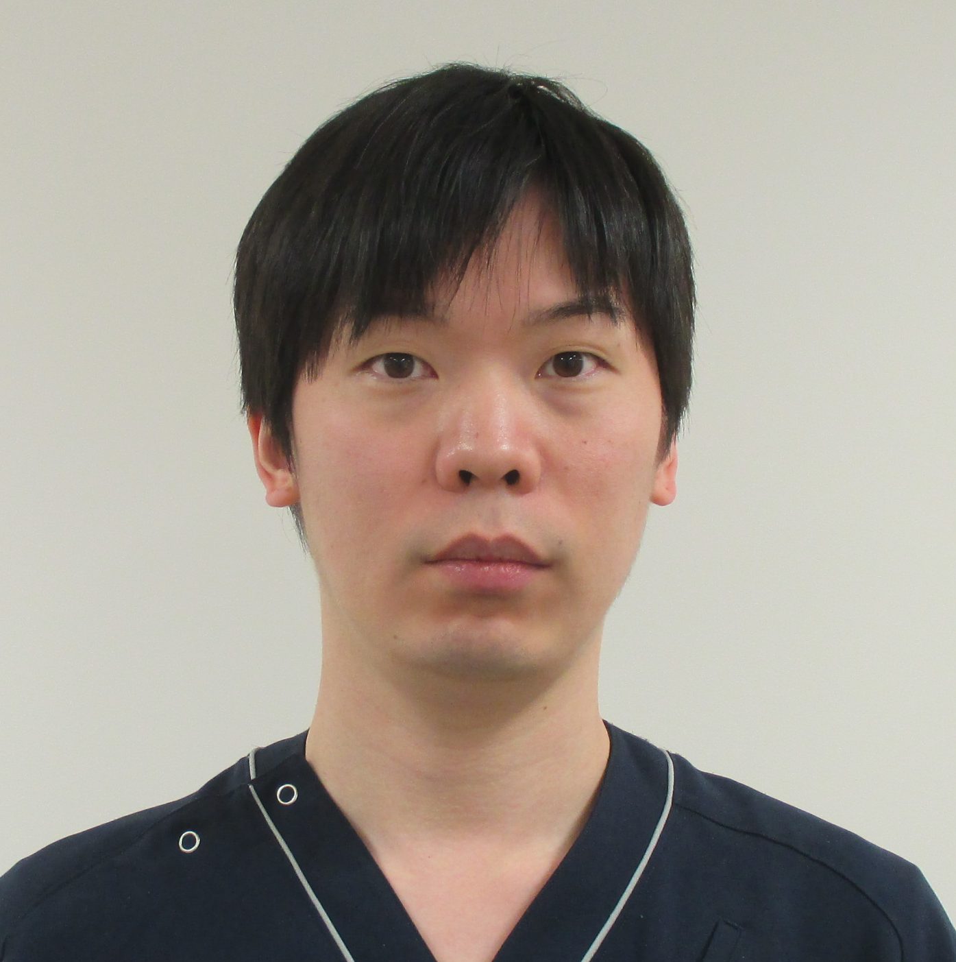 福島県立医科大学の助教、右近直之氏のポートレート。医療現場での専門性を示す服装を着用。