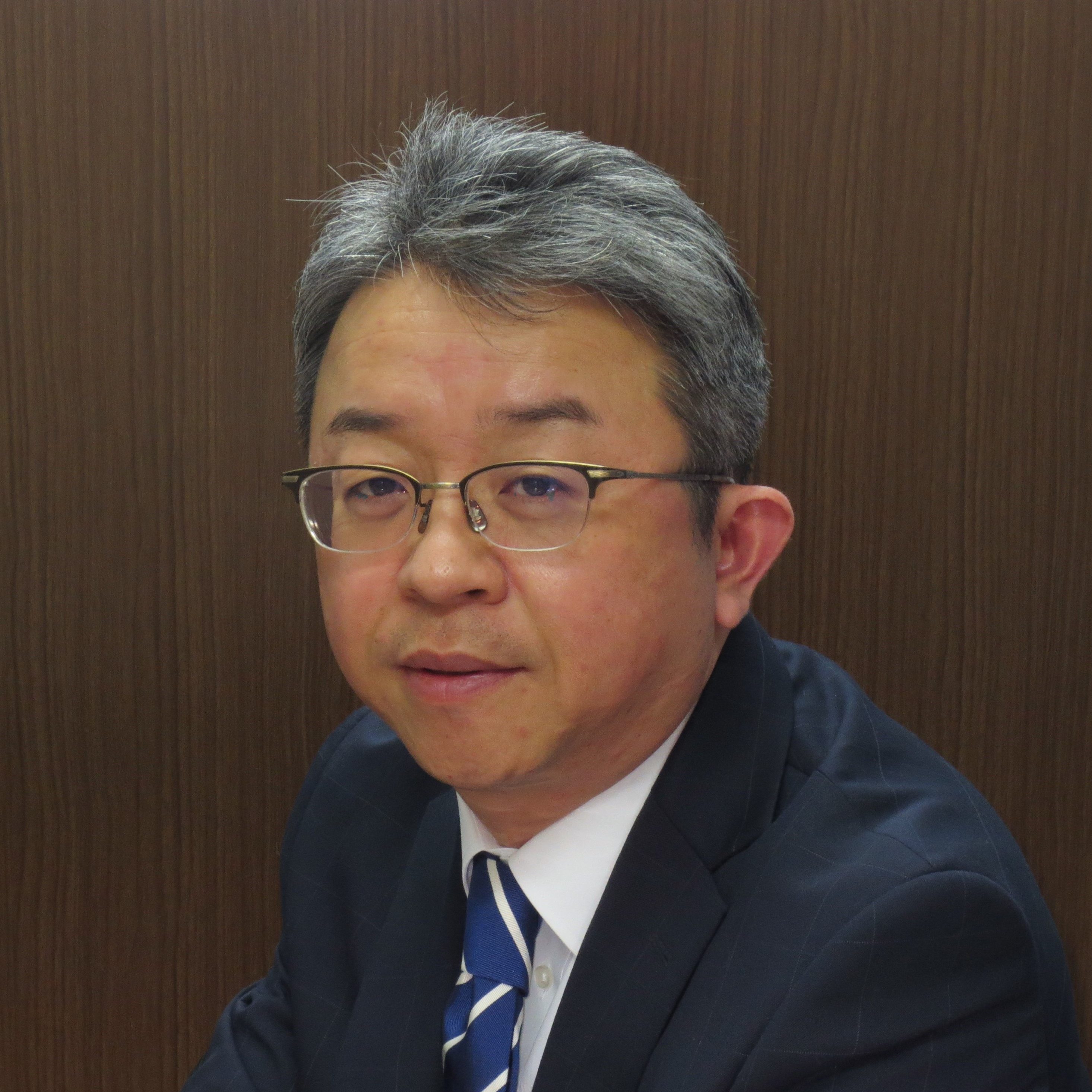 鈴木弘行教授が医療に関する話をしている様子。背景は木目調の壁。