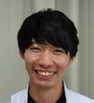 医療用白衣を着た男性が笑顔でカメラを見つめているポートレート。