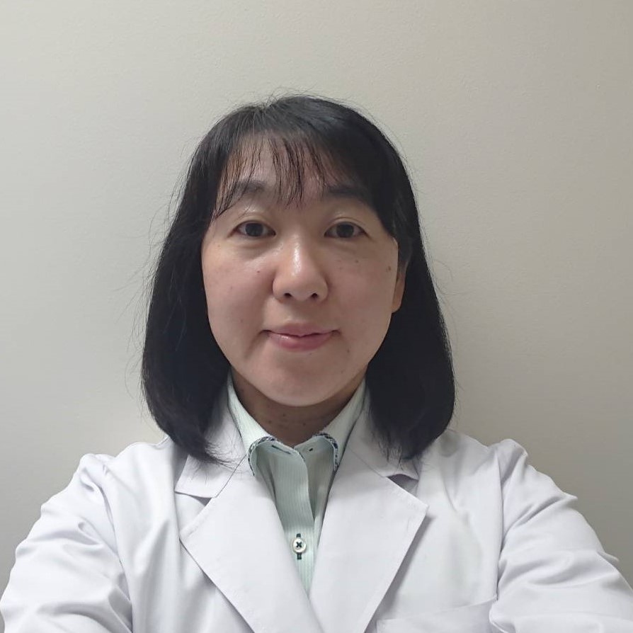臨床検査学科の助教、堀越裕子が白衣を着て自撮りした写真。