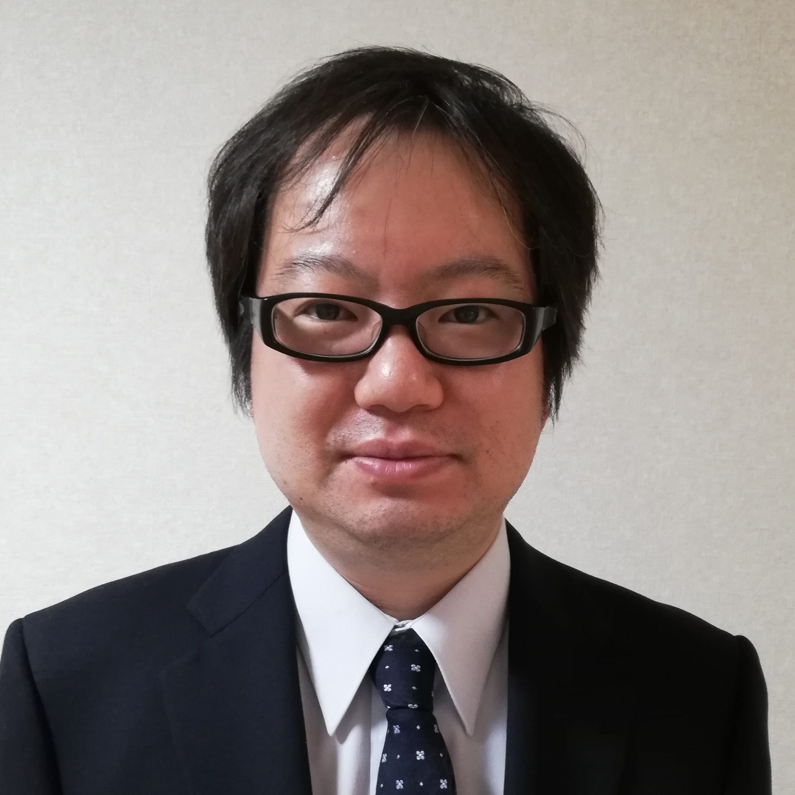 福島県立医科大学の准教授、植村武文氏がスーツ姿で微笑んでいるポートレート。